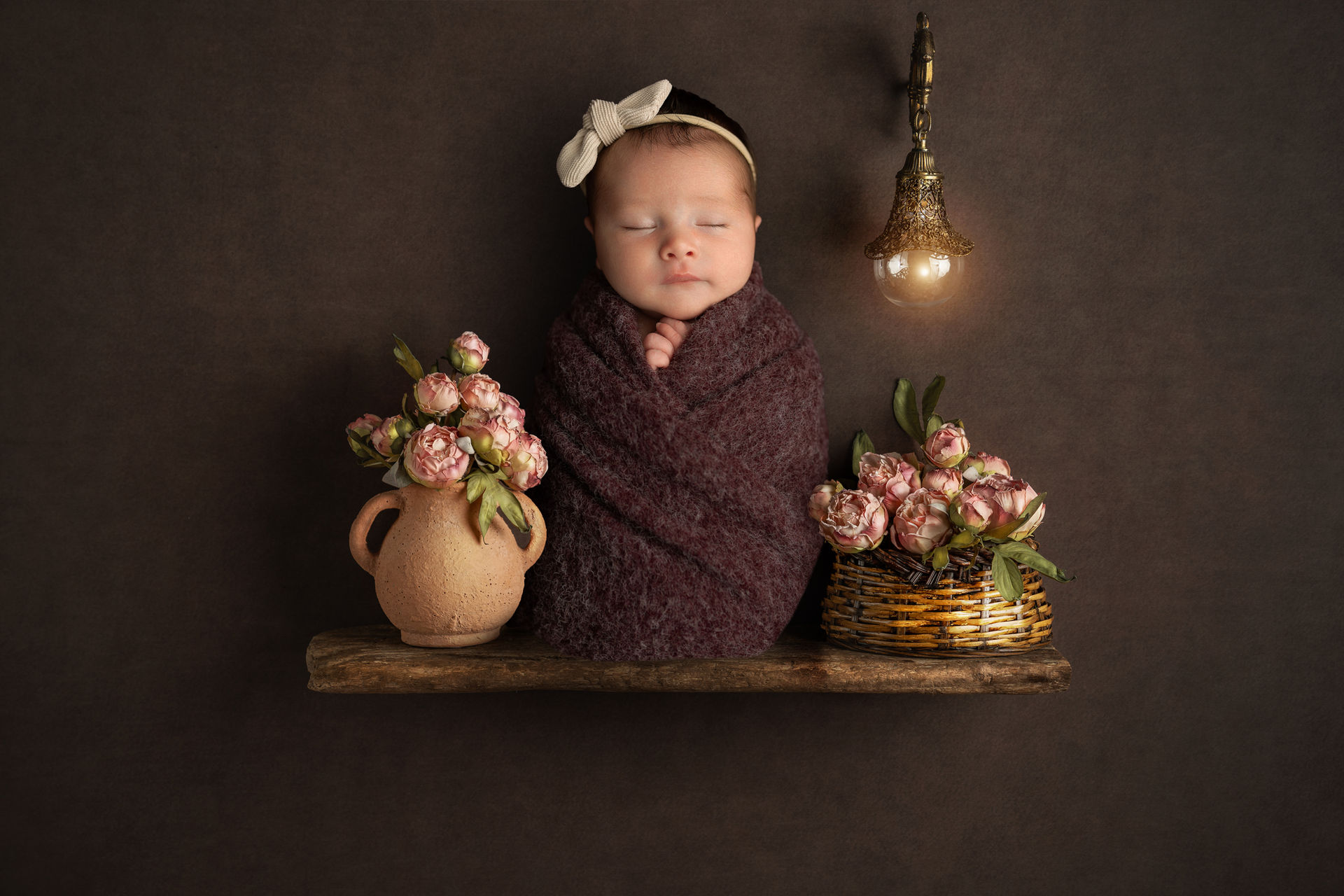 Neugeborenenportrait mit Blumen und warmem Licht