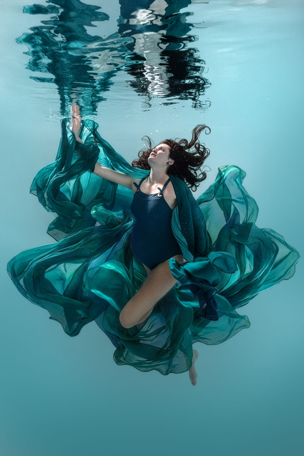 Frau mit türkisfarbenem Kleid unter Wasser