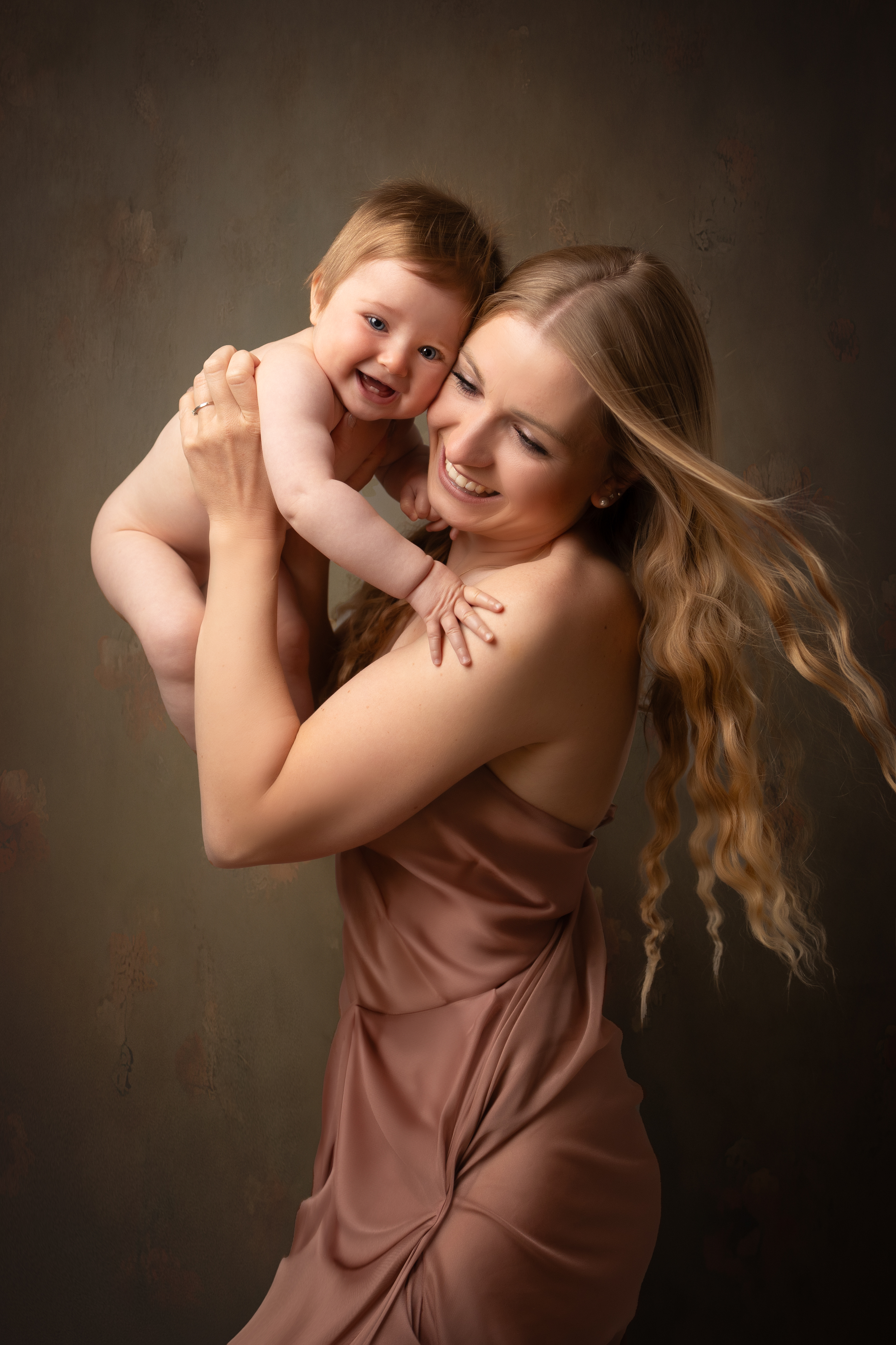 Lachende Mutter mit ihrem Kind auf dem Arm