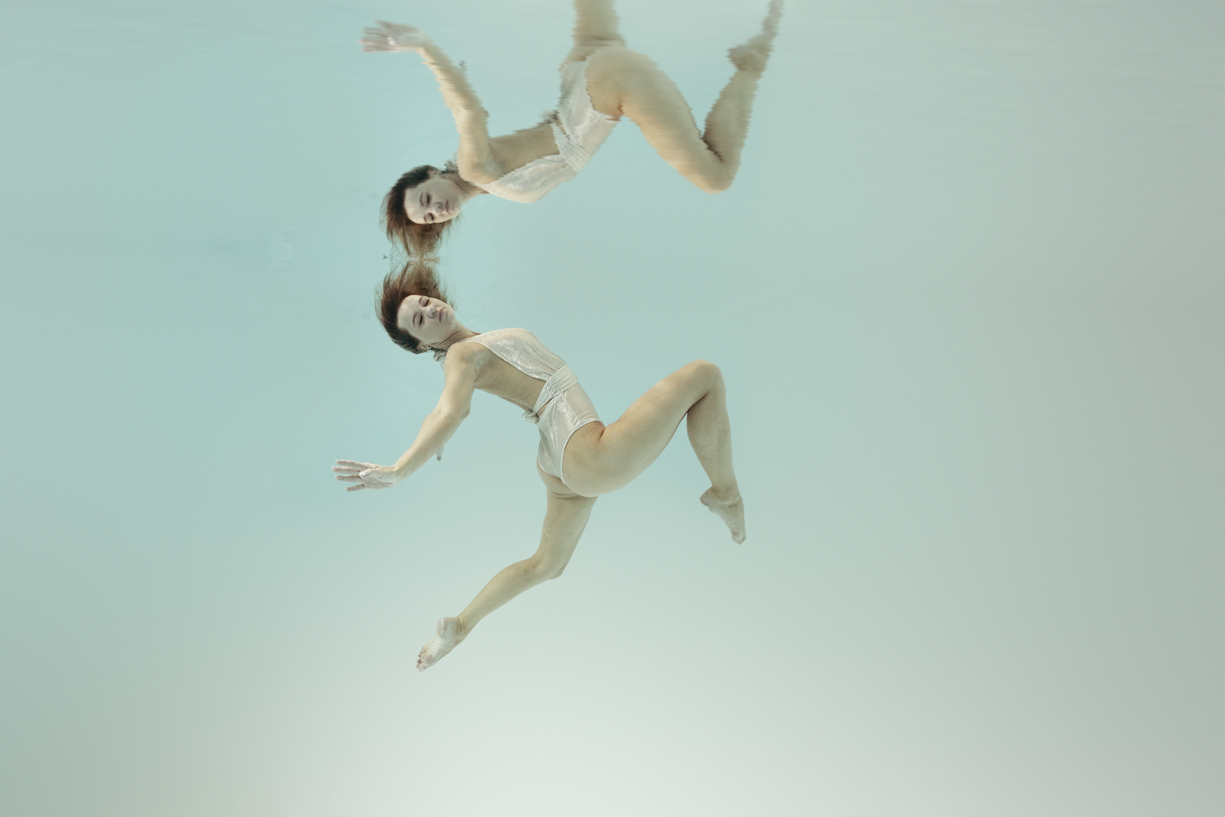 Zwei Frauen in weißen Kleidern unter Wasser